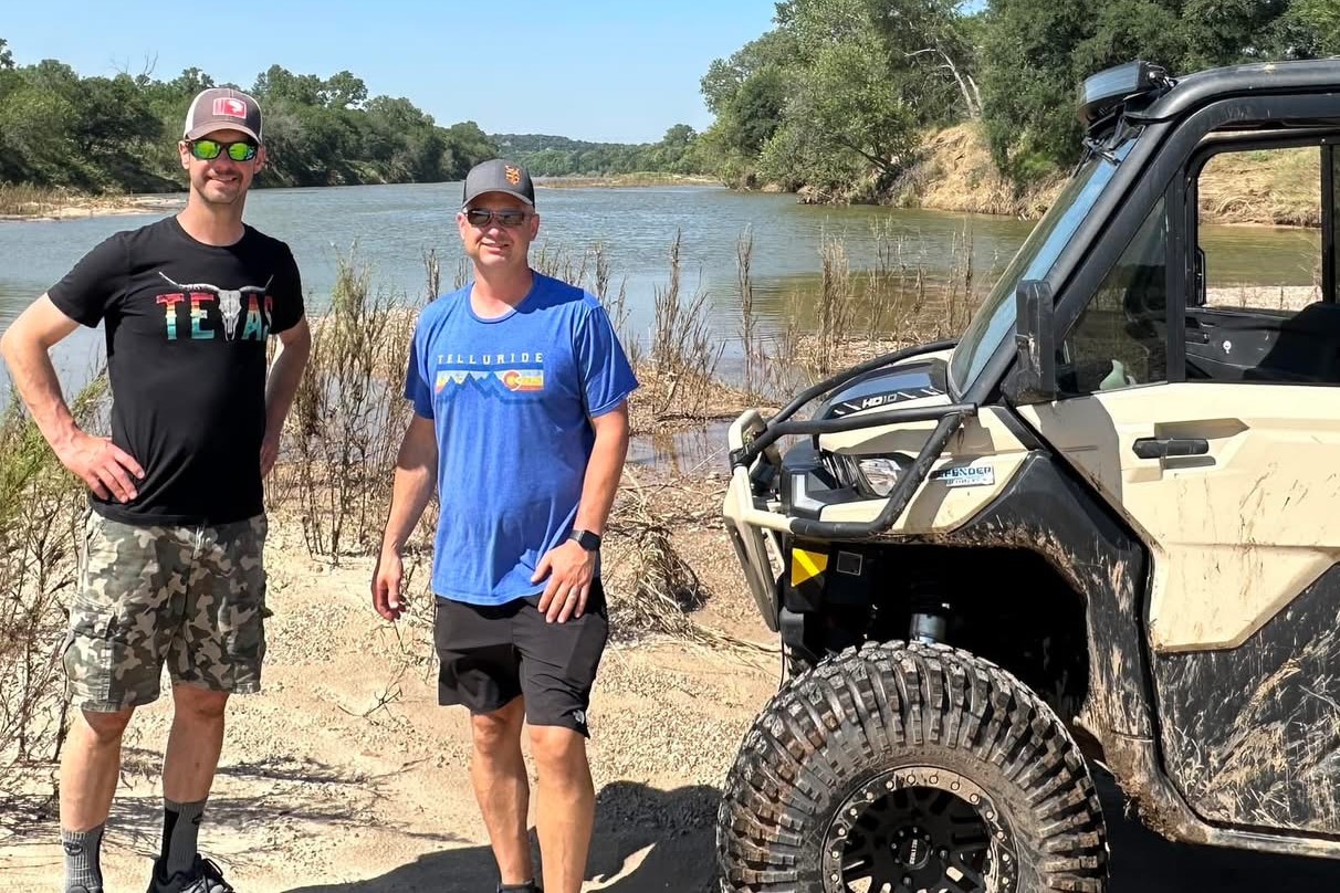 Luke and Dave Pine, of Pine Brothers Longhorns Next to a UTV by a Lake